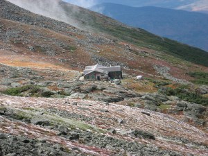 The Lakes hut from the top of Mt. Washington, Mt. Monroe and tundra garden also seen. A speck in the wilderness
